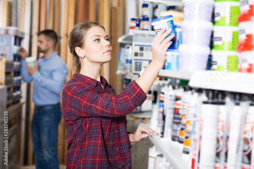 Woman is choosing with paint for repair