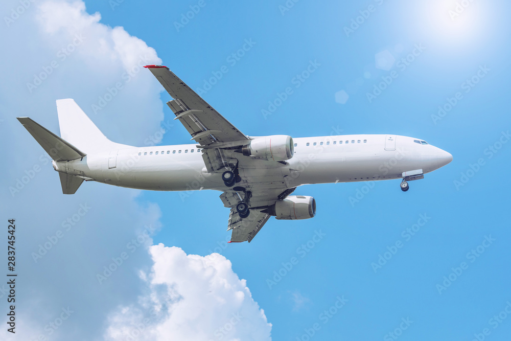Sky with clouds and sun, reflected glare light, and passenger airplane landing approach airport. Sky with clouds and sun, reflected glare light, and passenger airplane landing approach airport.