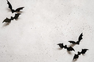 halloween decoration concept - black bats on white concrete background