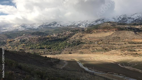 Panoramic view of a river bed surrounded by snow capped mountains in Beeqa Valley, the most important farming region of Lebanon photo