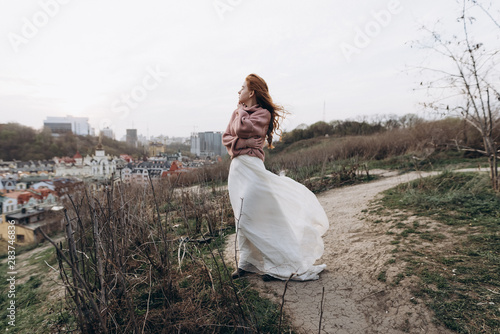 portrait of young redhead woman in wedding dress and sweater