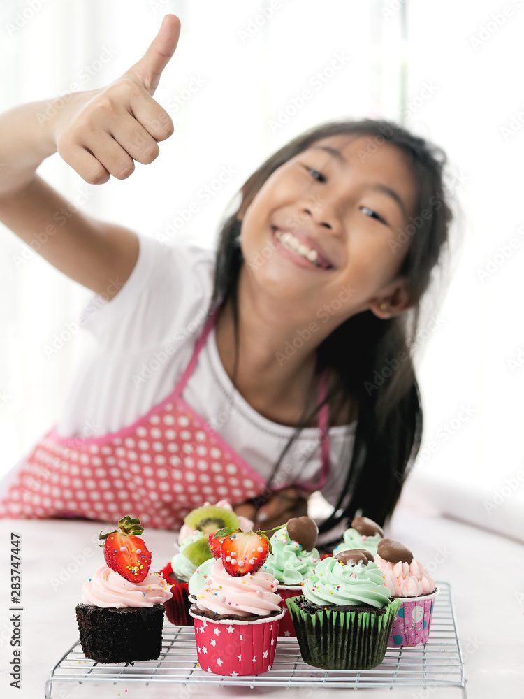 Girl with homemade cupcake on table, selective focus, lifestyle concept. Girl with homemade cupcake on table, selective focus, lifestyle concept.