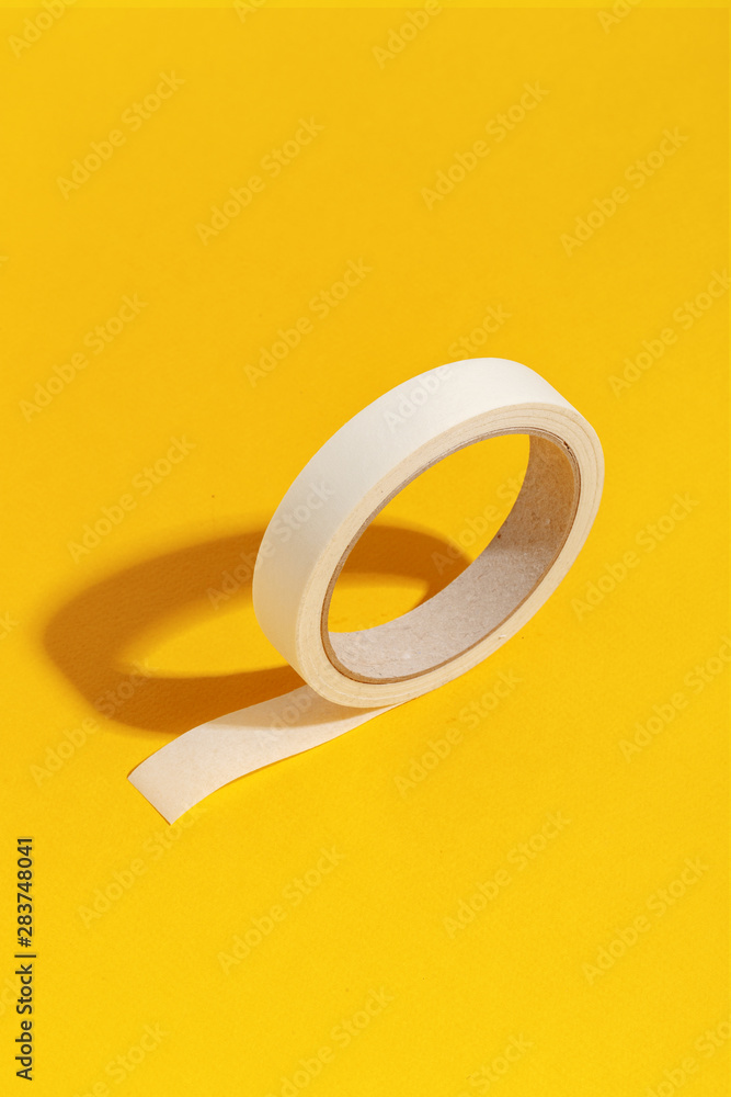 Roll of paper stationery tape on a yellow background Roll of paper stationery tape on a yellow background