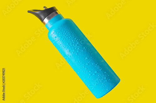 top view thermos water bottle. Blue water bottle wet isolated on yellow background