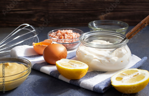 Mayonnaise sauce and ingredients for fresh homemade mayonnaise. Dark background. Close-up view