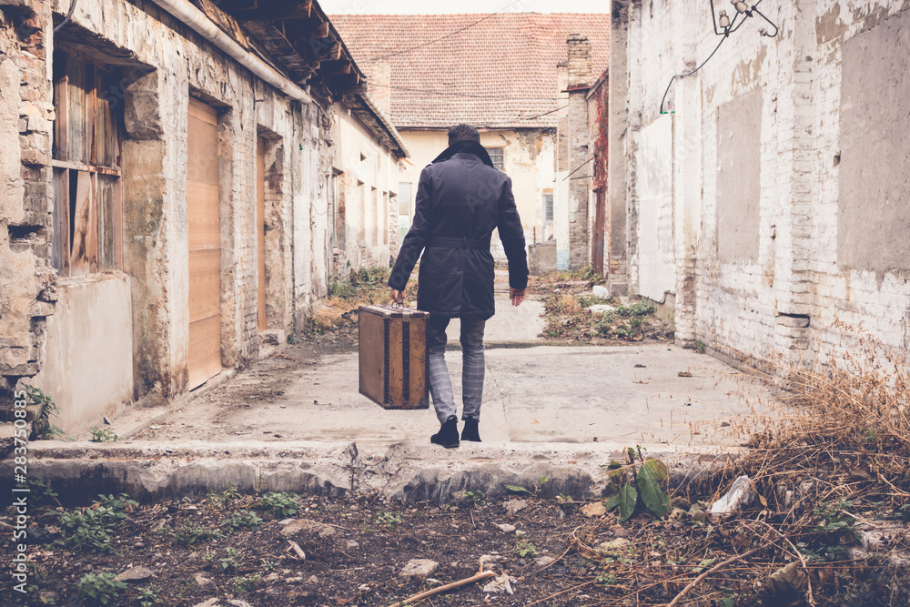 Back view of man carrying suitcase and walking away. Back view of man carrying suitcase and walking away.