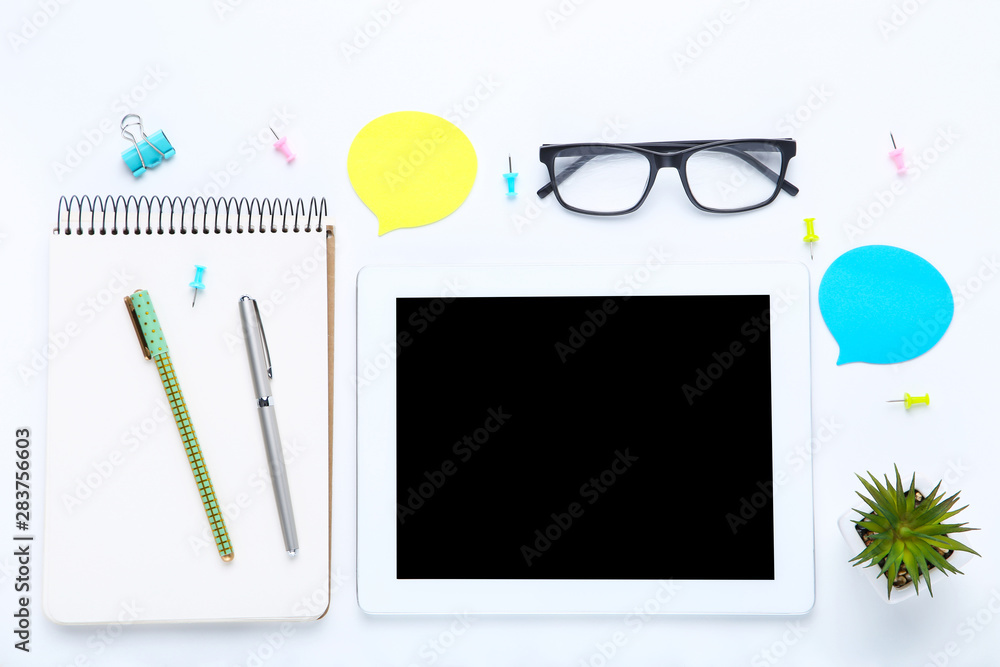 Tablet computer with office supplies on white background Tablet computer with office supplies on white background