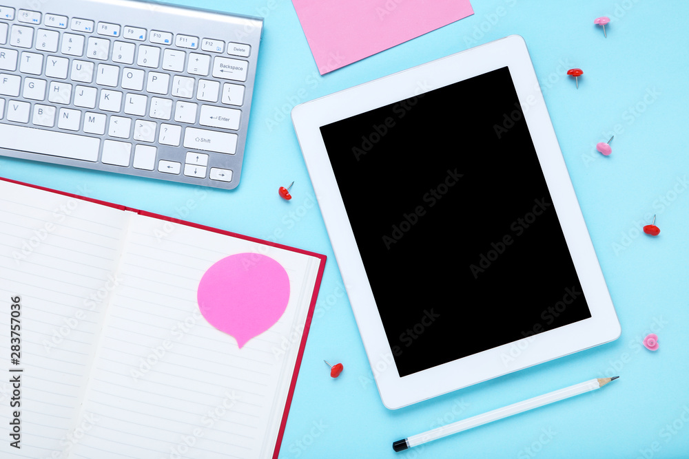 Tablet and computer keyboard with office supplies on blue background Tablet and computer keyboard with office supplies on blue background