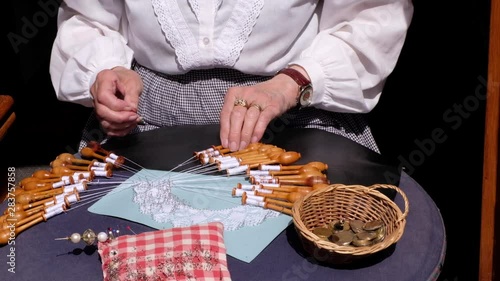 Old grandmother lace making in the city. Black isolated background. Brussels, Belgium