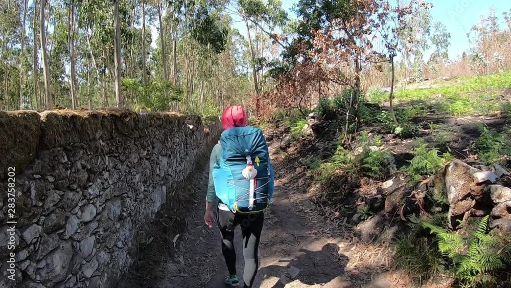 Girl goes on the trail. Camino de Santiago through Vila Praia De Ancora. Camino Portugues. Girl goes on the trail. Camino de Santiago through Vila Praia De Ancora. Camino Portugues.