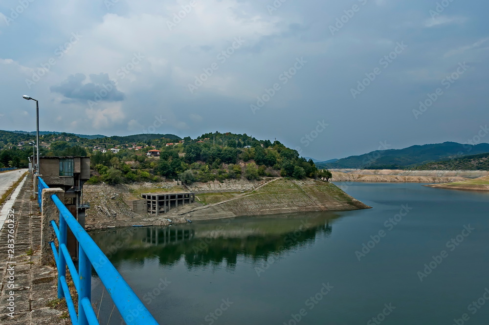 View from Topolnitsa dam, lake or barrage on the river Topolnitsa, part from village Muhovo and reservoir wall, Ihtiman region, Bulgaria, Europe 