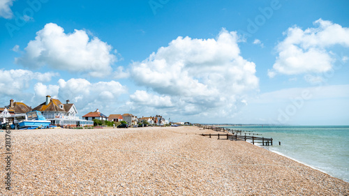 Pevensey Bay, East Sussex, England. Traditional beach houses along the coastline of the south coast of England on a bright summers day. photo