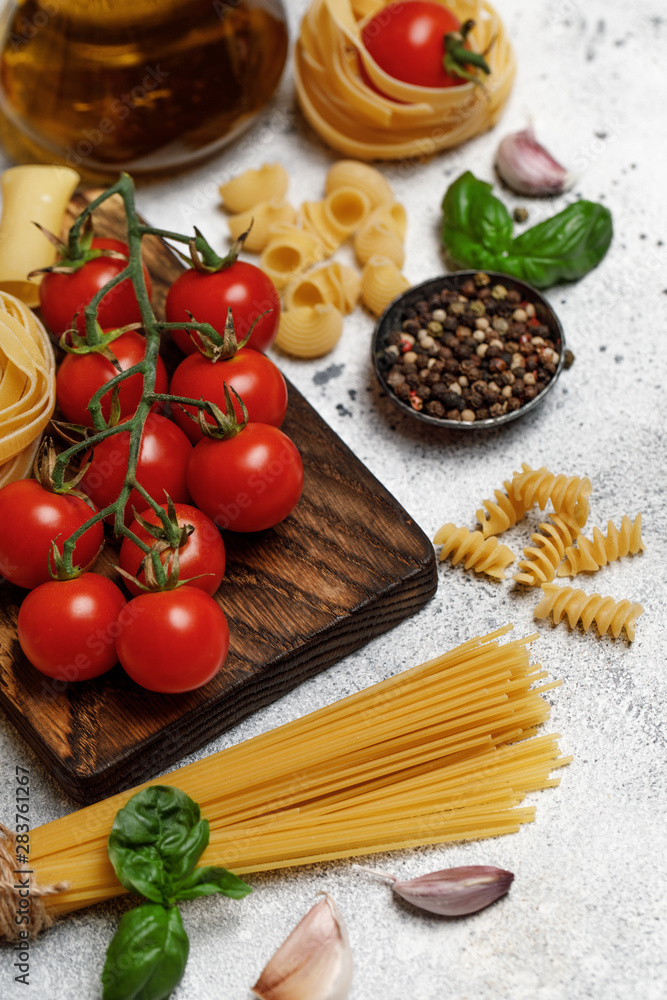Uncooked pasta on grey stone background. Top view. Raw pasta with ingredients for cooking. Food concept. Italian food Uncooked pasta on grey stone background. Top view. Raw pasta with ingredients for cooking. Food concept. Italian food