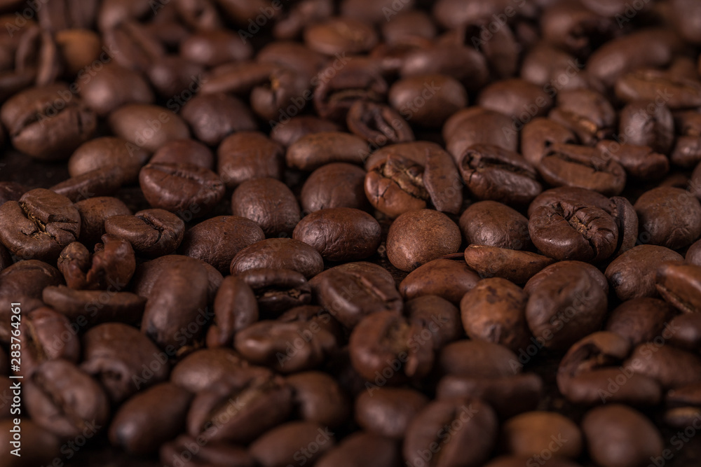 Obraz premium Coffee beans on stone background. Top view with copy space for your text. Roasted coffee beans background. Beans texture, macro