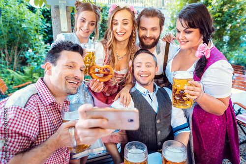 Cheerful group of friends taking a selfie in Bavarian beer garden