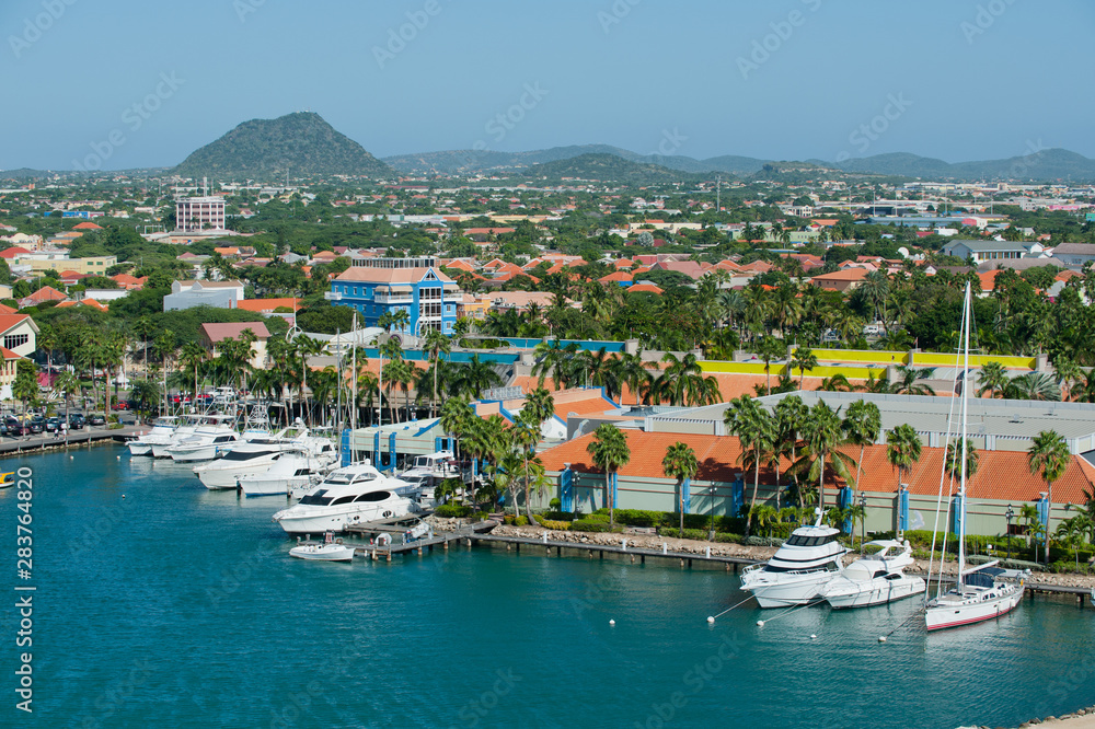 A view overlooking the marina community buildings and  mountains of the Island of Aruba in the Caribbean - Image