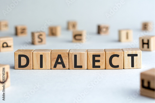 dialect - word from wooden blocks with letters, form of a language dialect concept, random letters around, white  background photo