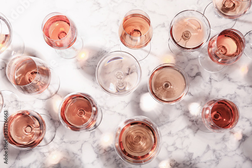 Fototapeta Naklejka Na Ścianę i Meble -  Different glasses with rose wine on marble background, flat lay