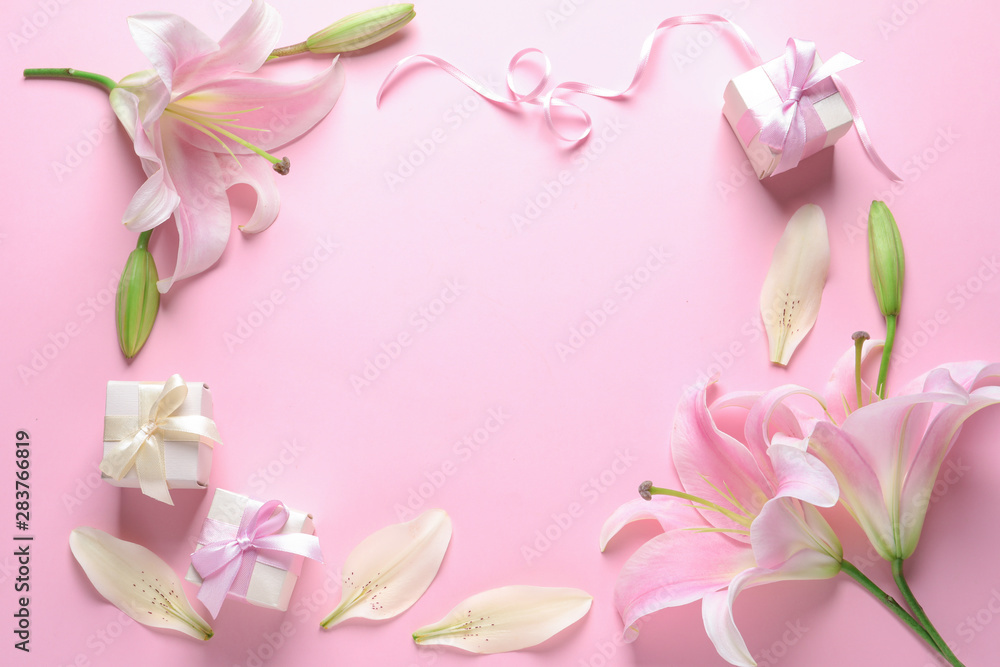 Frame made of fresh lilies and gift boxes on pink background, flat lay. Space for text