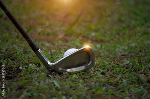 Golf ball and golf club in beautiful golf course at Thailand. Collection of golf equipment resting on green grass with green background