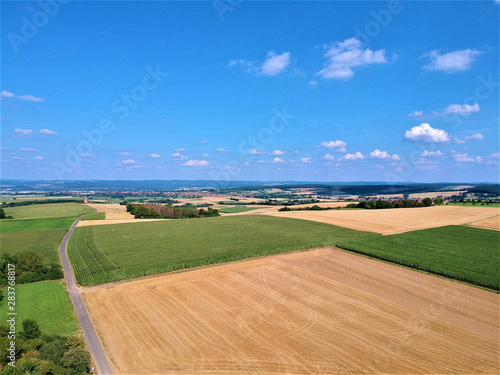 Farmland with country road sky and clouds photographed from above
