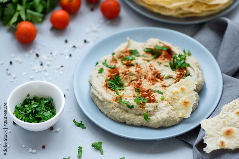 Eggplant dip baba ganoush (mutabbal) with herbs and paprika on gray wooden background. Selective focus. Traditional arabian food Eggplant dip baba ganoush (mutabbal) with herbs and paprika on gray wooden background. Selective focus. Traditional arabian food