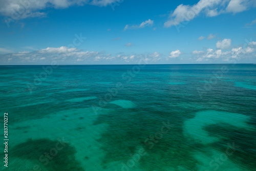 shallow sea meets blue sky and clouds at distant horizon