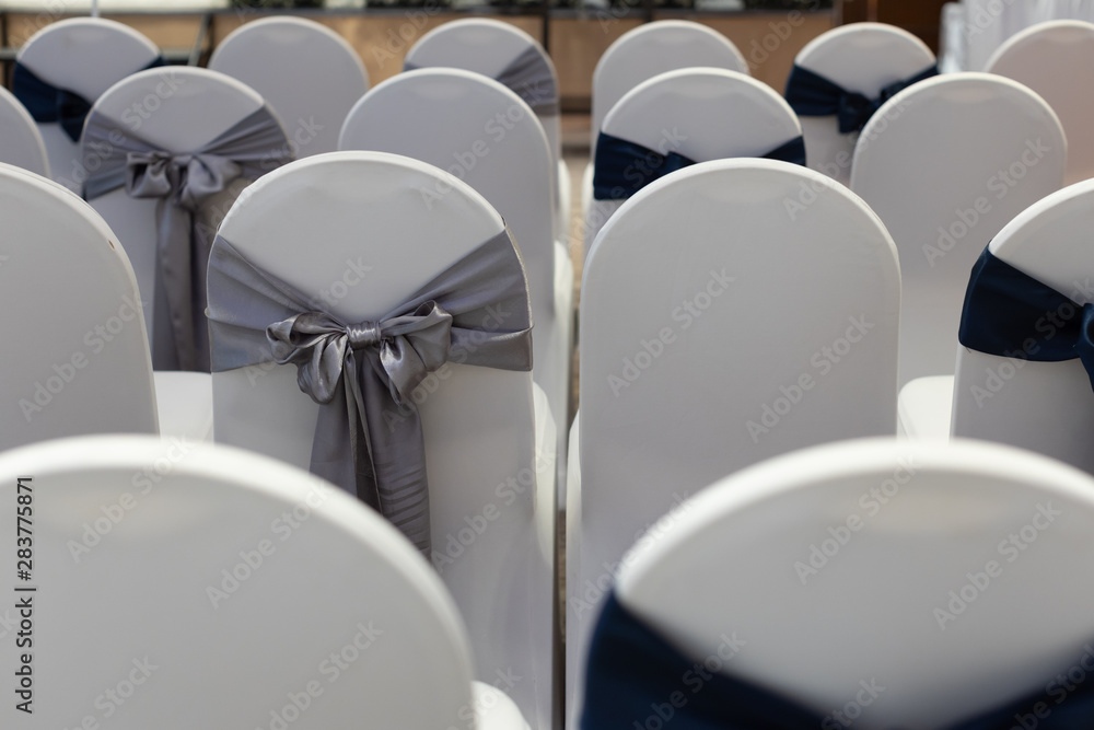Wedding reception chairs in row decorated with ribbon. Wedding reception chairs in row decorated with ribbon.