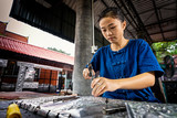 Silverware making. Thai women are making silverware. The original of the silver craftsmen on Wua Lai road, Chiang Mai. Thailand.