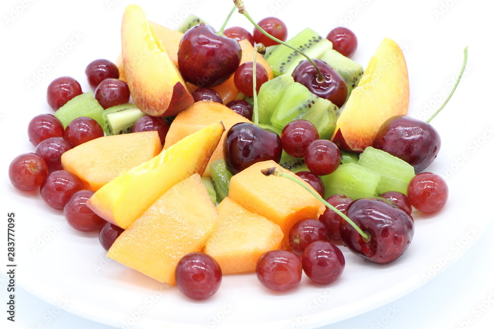 Close up of fresh, colorful fruits on a plate isolated on white background Close up of fresh, colorful fruits on a plate isolated on white background
