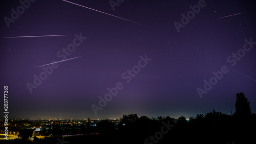 Forlì, Emilia Romagna, Italy. August 12th 2019. Perseids meteor shower over Forlì. main colors: purple, yellow, black.
