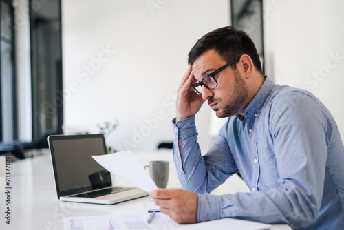 Stressed out and worried overworked businessman in office working under pressure and tight deadline