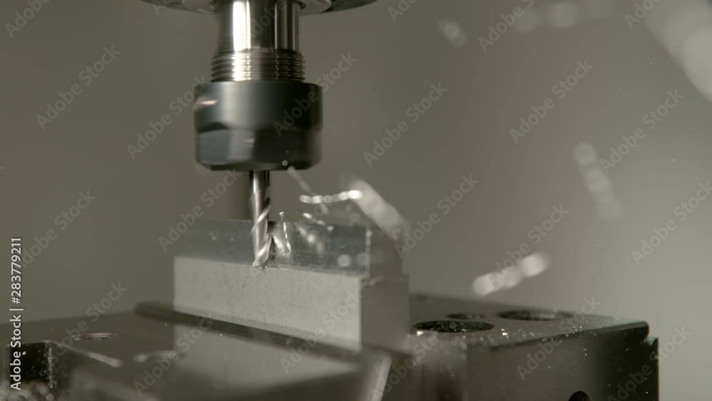 SLOW MOTION, MACRO, DOF: Shiny chips of metal come flying off a workpiece during end milling. Sharp cutter spinning and shaving the side of a matt block of aluminium. Conventional metalwork method. SLOW MOTION, MACRO, DOF: Shiny chips of metal come flying off a workpiece during end milling. Sharp cutter spinning and shaving the side of a matt block of aluminium. Conventional metalwork method.