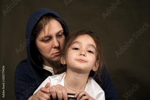 Shooting in the Studio.  Woman wearing a sweater. Sitting next to the suitcase. Sitting next to her daughter