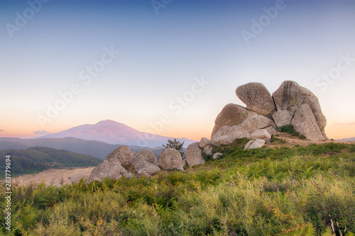 Il megalite Aquila delle Rocche dell'Argimusco e sullo sfondo l'Etna in Montalbano Elicona, Sicilia photo