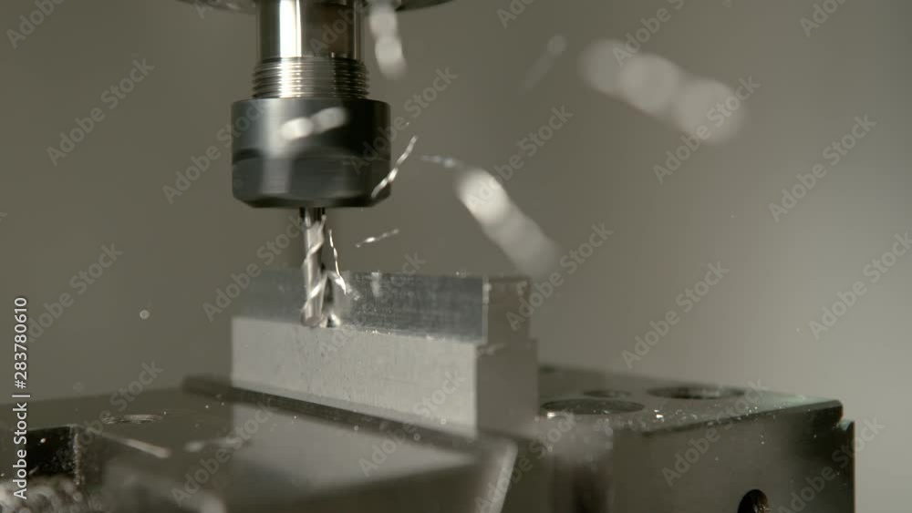 SLOW MOTION, MACRO, DOF: Sharp industrial drill spinning and end milling a matt piece of aluminium. Automated lathing equipment processing a workpiece during the end milling process. Shavings flying SLOW MOTION, MACRO, DOF: Sharp industrial drill spinning and end milling a matt piece of aluminium. Automated lathing equipment processing a workpiece during the end milling process. Shavings flying