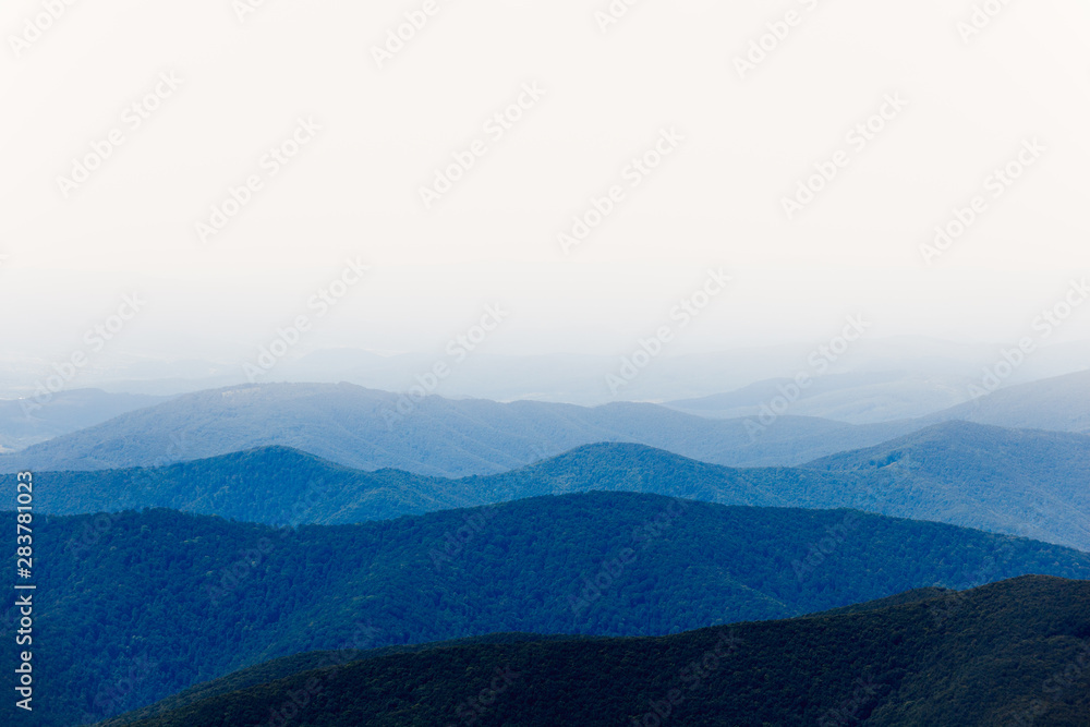 Mountain view with blue hills and white sky in the fog Mountain view with blue hills and white sky in the fog