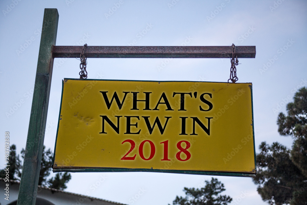 Handwriting text What'S New In 2018. Concept meaning Year resolution Goals Career achievements Technology Messages object location yellow banner frame metal board billboard yellow