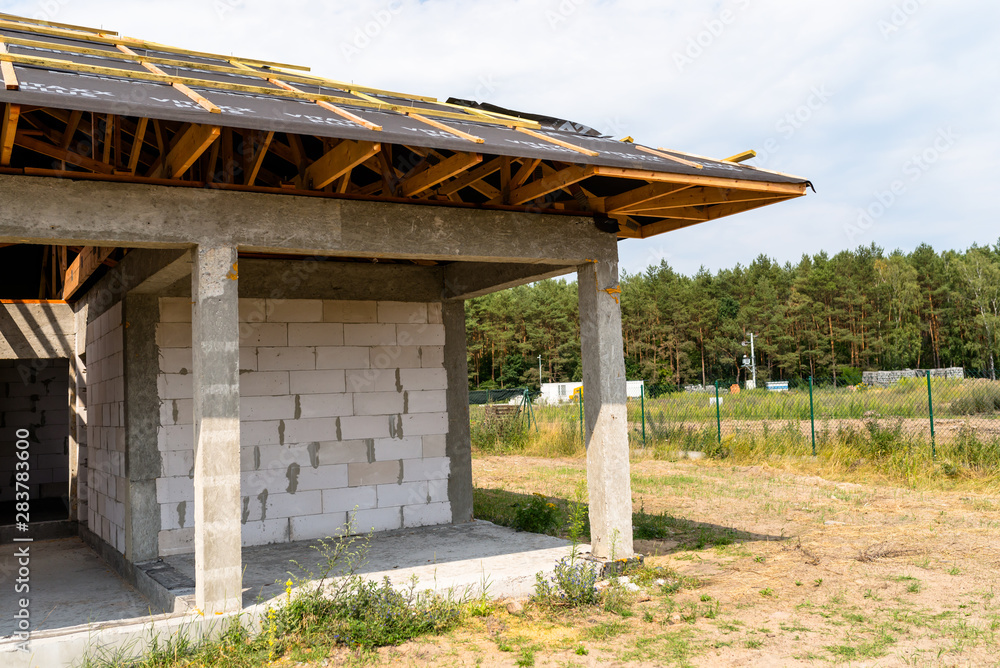 Roof trusses covered with a membrane on a detached house under construction, visible roof elements, battens, counter battens, rafters.