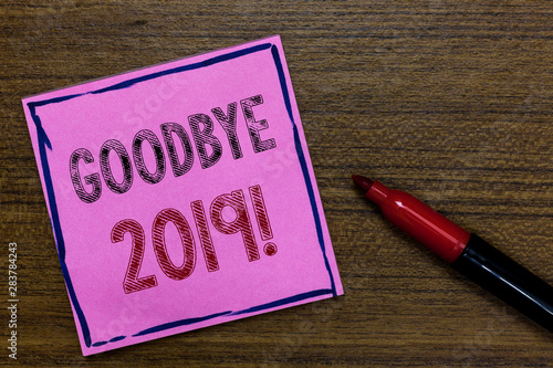 Text sign showing Goodbye 2019. Conceptual photo New Year Eve Milestone Last Month Celebration Transition Purple Paper Important reminder Communicate ideas Marker Wooden background photo