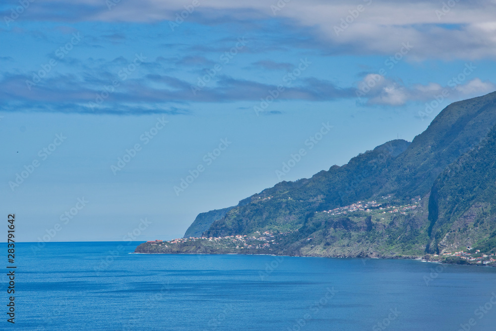 View from viewpoint in Porto Moniz to Seixal and cliffs in Atlantic ocean on Madeira island, Portugal in sunny summer day 