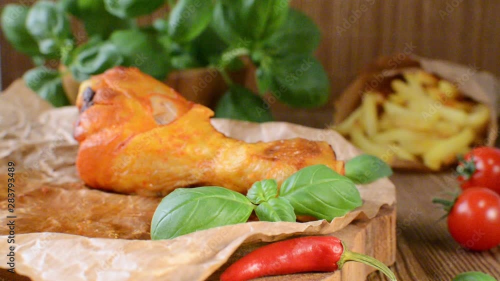 a hand takes grilled chicken legs and puts leftovers back a hand takes grilled chicken legs and puts leftovers back