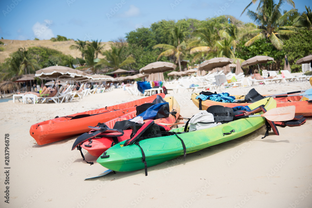 Couple of colorful kayaks with tourist belongings on the beach
