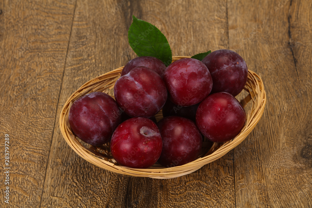 Plum heap in the wooden basket Plum heap in the wooden basket