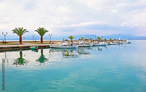 landscape of Nafplio harbor with fishing boats reflected on water - Argolis Greece 