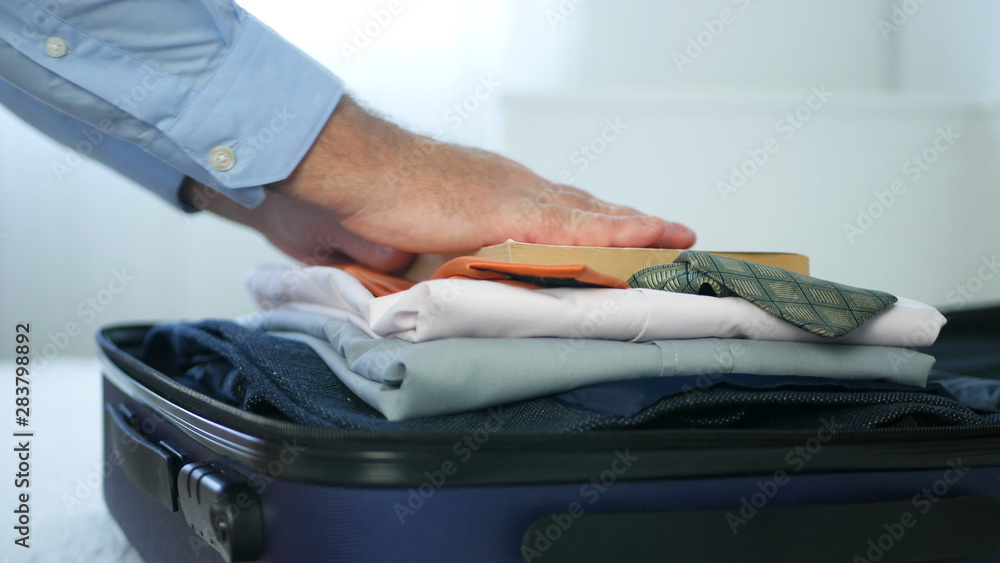 Businessman Prepare a Suitcase with Clothes and Put Inside a Reading Book 
