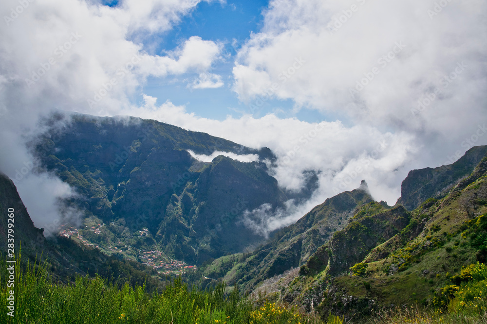 View from the hiking trail at the Boca da Corrida belvedere on the Encumeada pass on Madeira Island, Portugal in summer, View to the village of Curral das Freiras 
