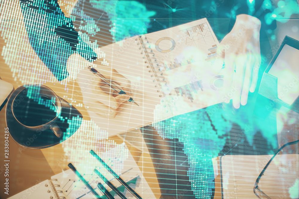 International business hologram over hands taking notes background. Concept of success. Multi exposure International business hologram over hands taking notes background. Concept of success. Multi exposure