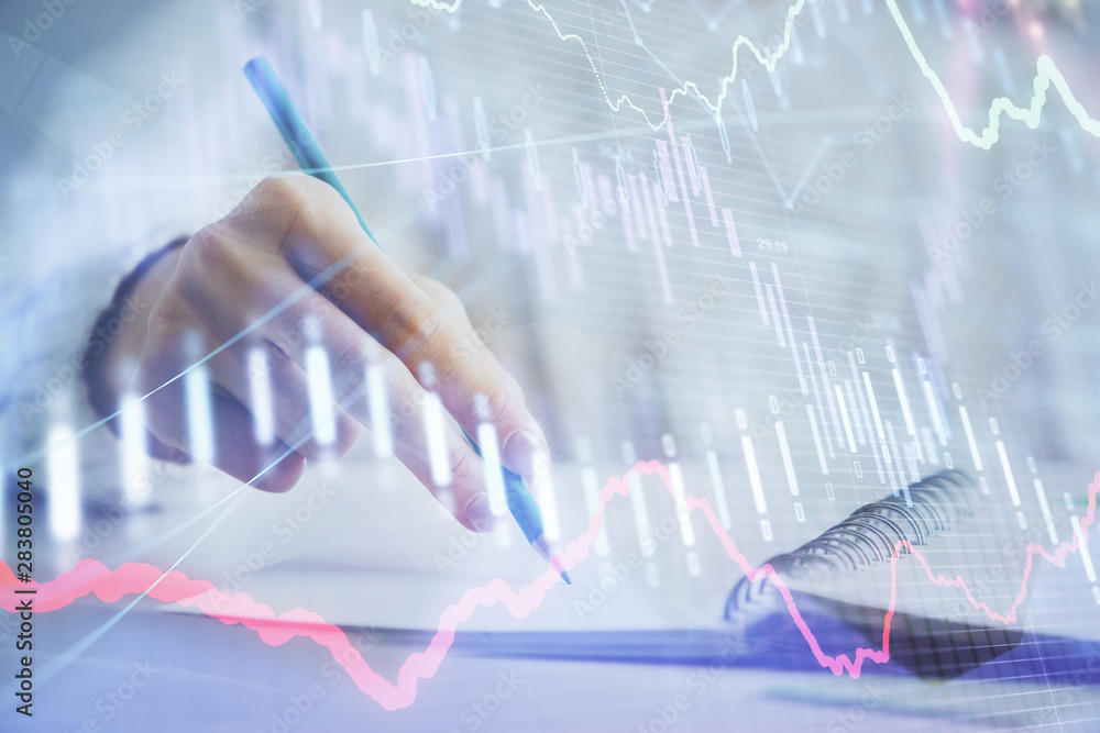 Financial forex graph displayed on hands taking notes background. Concept of research. Double exposure Financial forex graph displayed on hands taking notes background. Concept of research. Double exposure