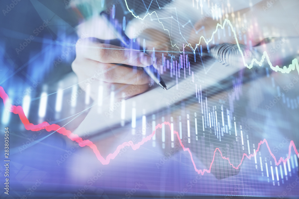 Financial forex graph displayed on hands taking notes background. Concept of research. Double exposure Financial forex graph displayed on hands taking notes background. Concept of research. Double exposure
